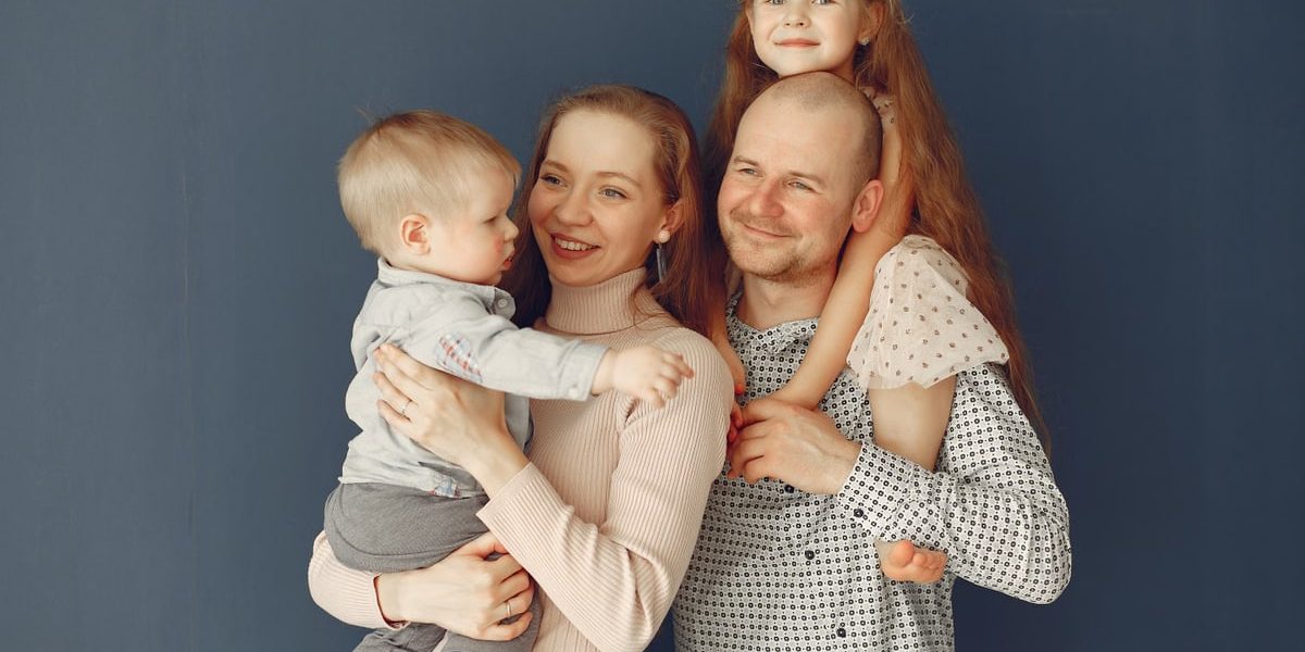 A joyful family portrait showcasing parents and their two children, expressing love and togetherness.