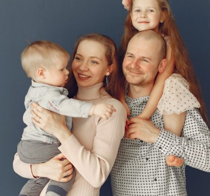A joyful family portrait showcasing parents and their two children, expressing love and togetherness.