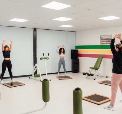 Three women engage in a workout session in a brightly lit, modern fitness studio in Yalova, Türkiye.