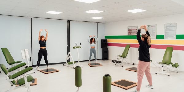 Three women engage in a workout session in a brightly lit, modern fitness studio in Yalova, Türkiye.
